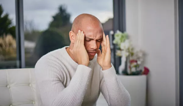Man suffering from migraine on a sofa