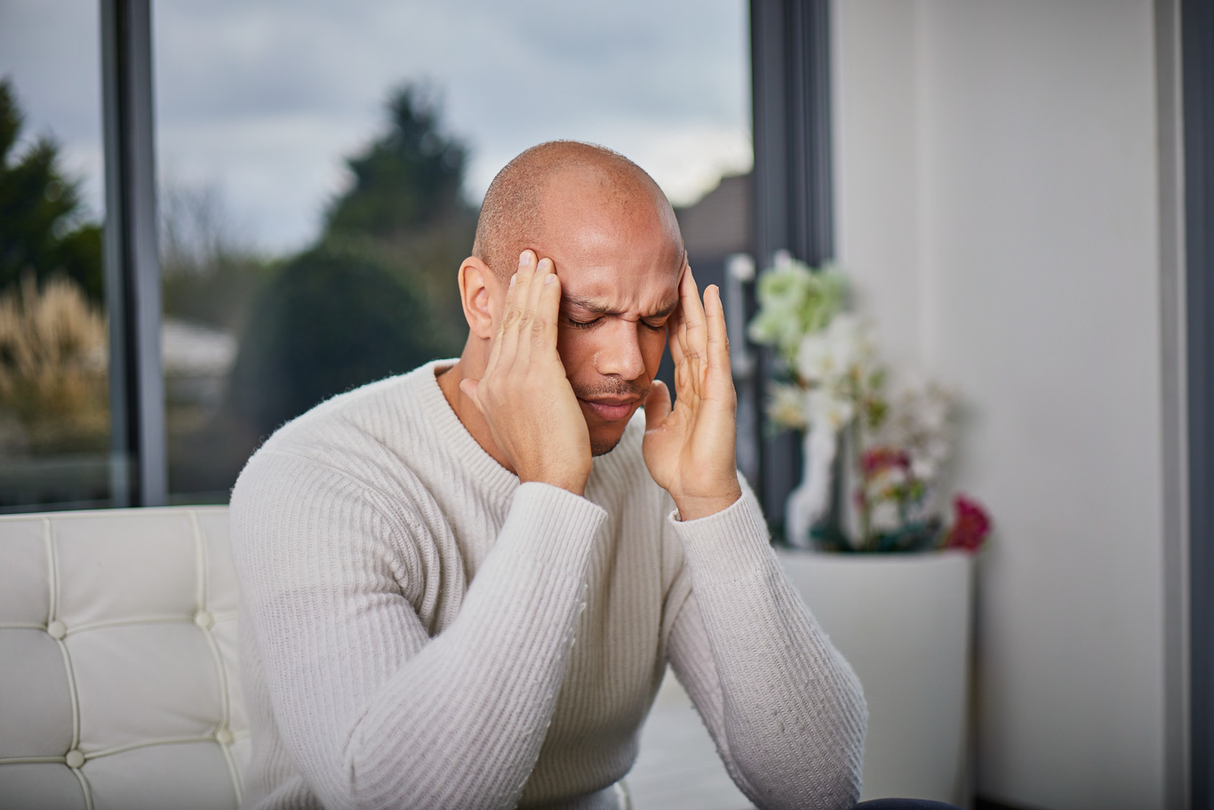 Man suffering from migraine on a sofa